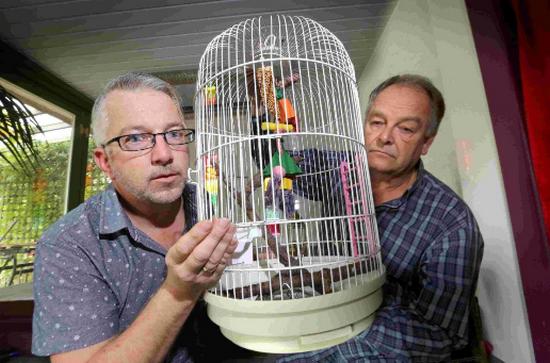 Эндрю Саттон и его друг с клеткой для попугая Бекки