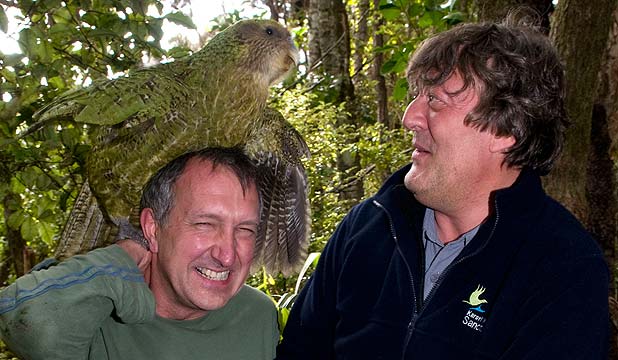 Совиный попугай Сирокко сидит на голове Марка Карвардина, рядом со Стивеном Фраем