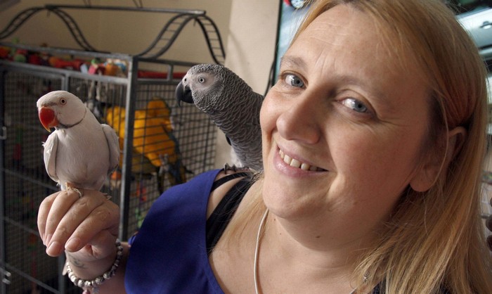 Сара Лисетт с кольчатым попугаем и жако в приюте