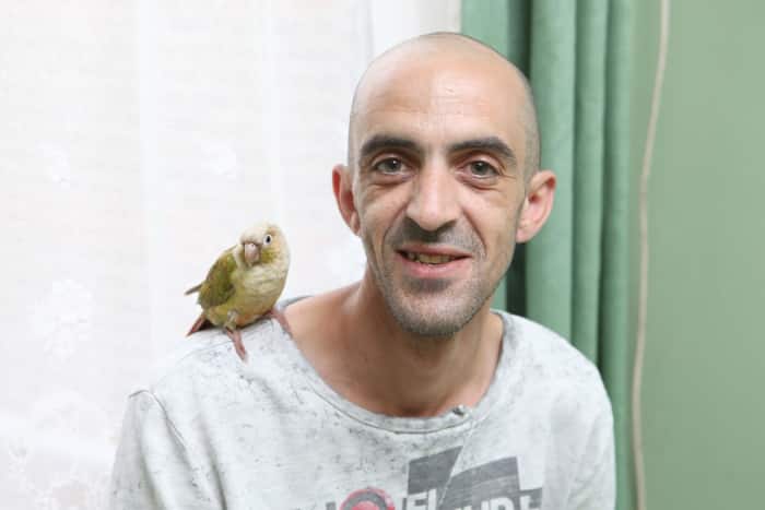 Британец Дин Заммит с попугаем на плече